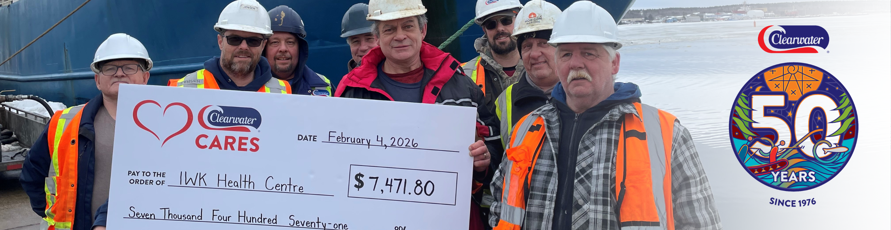 Workers in hard hats hold a $7,471.80 Clearwater Cares donation cheque for IWK Health.