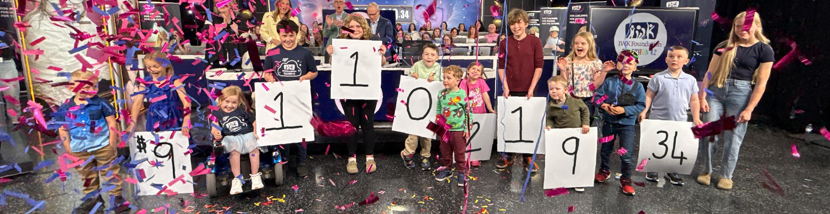 Children holding the fundraising total for the 42nd IWK Telethon for Children 
