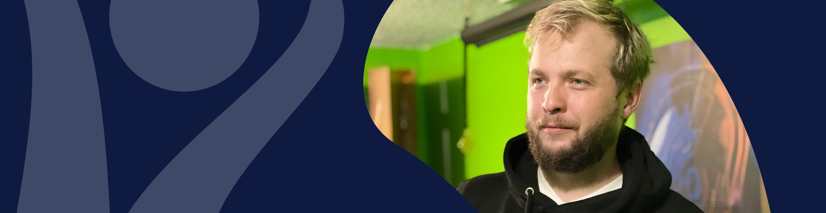 Alex Green wearing a black hoodie, photographed against a bright green and dark blue background with abstract graphic shapes.