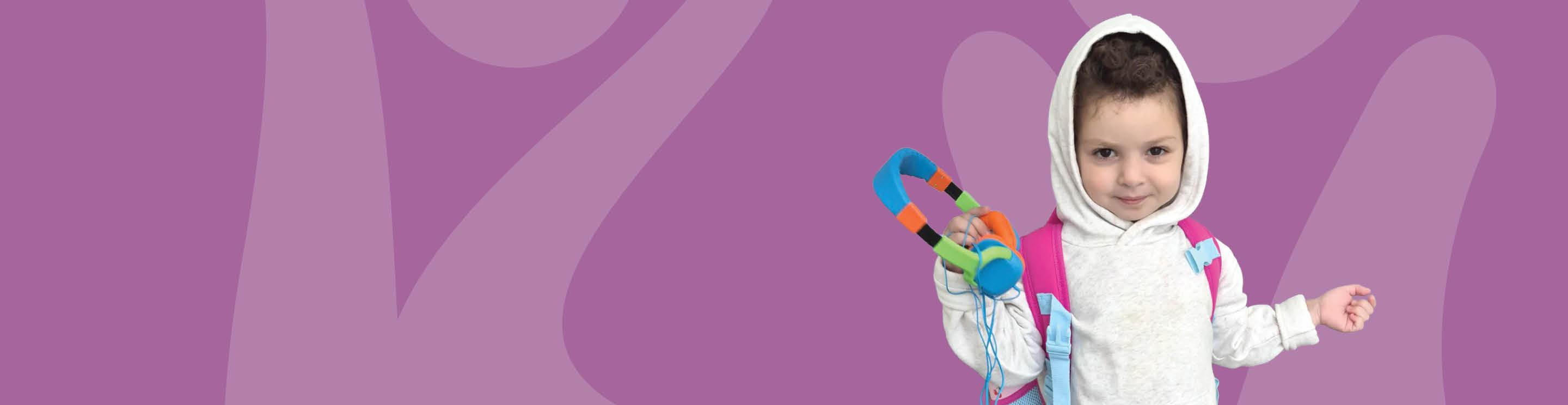 Kenza in a white hoodie holding colorful headphones, standing against a purple background.