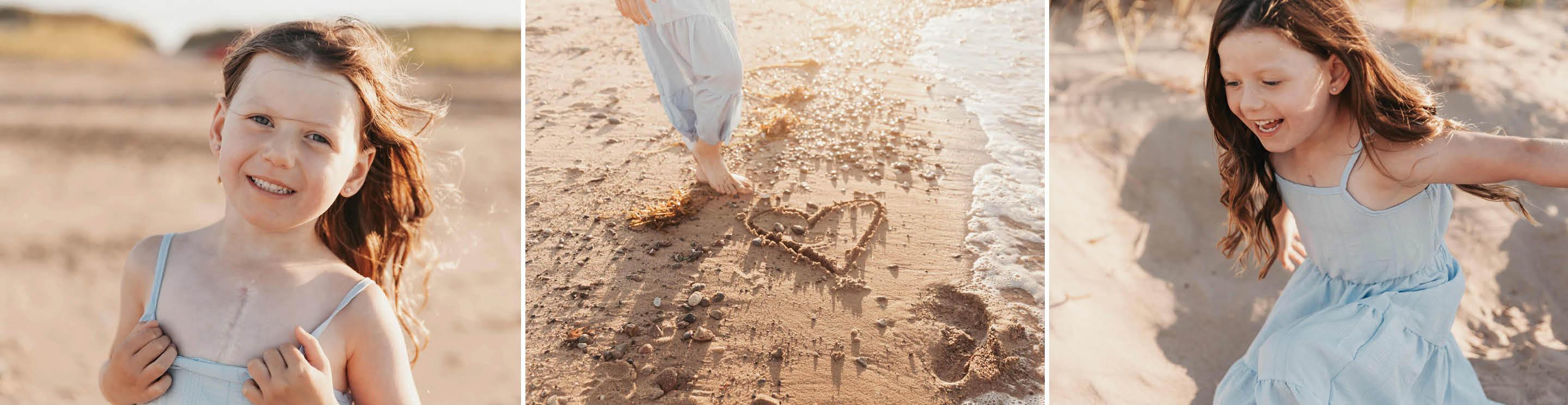 Baylee playing on a sandy beach, with a heart drawn in wet sand and footprints by the shoreline.