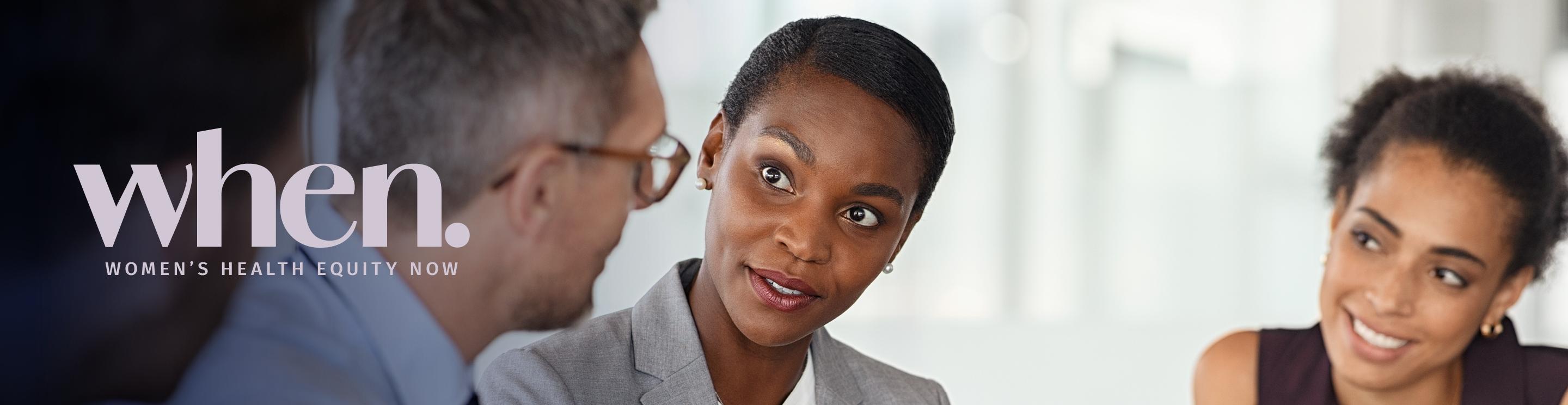 A man and two women in discussion in a professional setting.