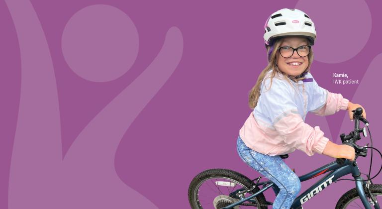 Kamie wearing a bike helmet and glasses while riding a bicycle.