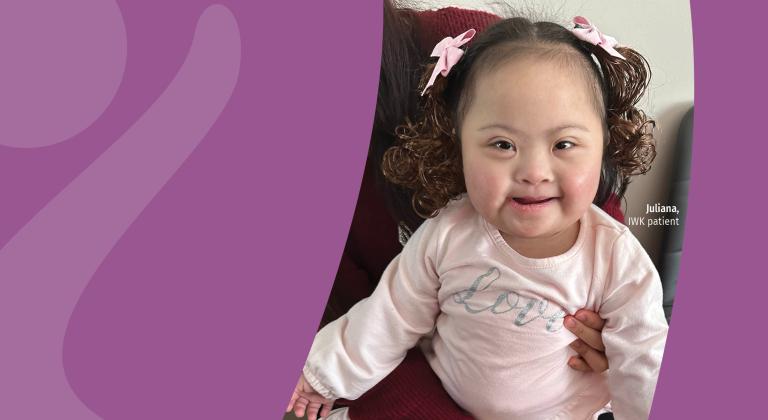 Juliana wearing pink bows in her brown curly hair.