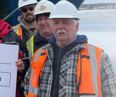 Workers in hard hats hold a $7,471.80 Clearwater Cares donation cheque for IWK Health.